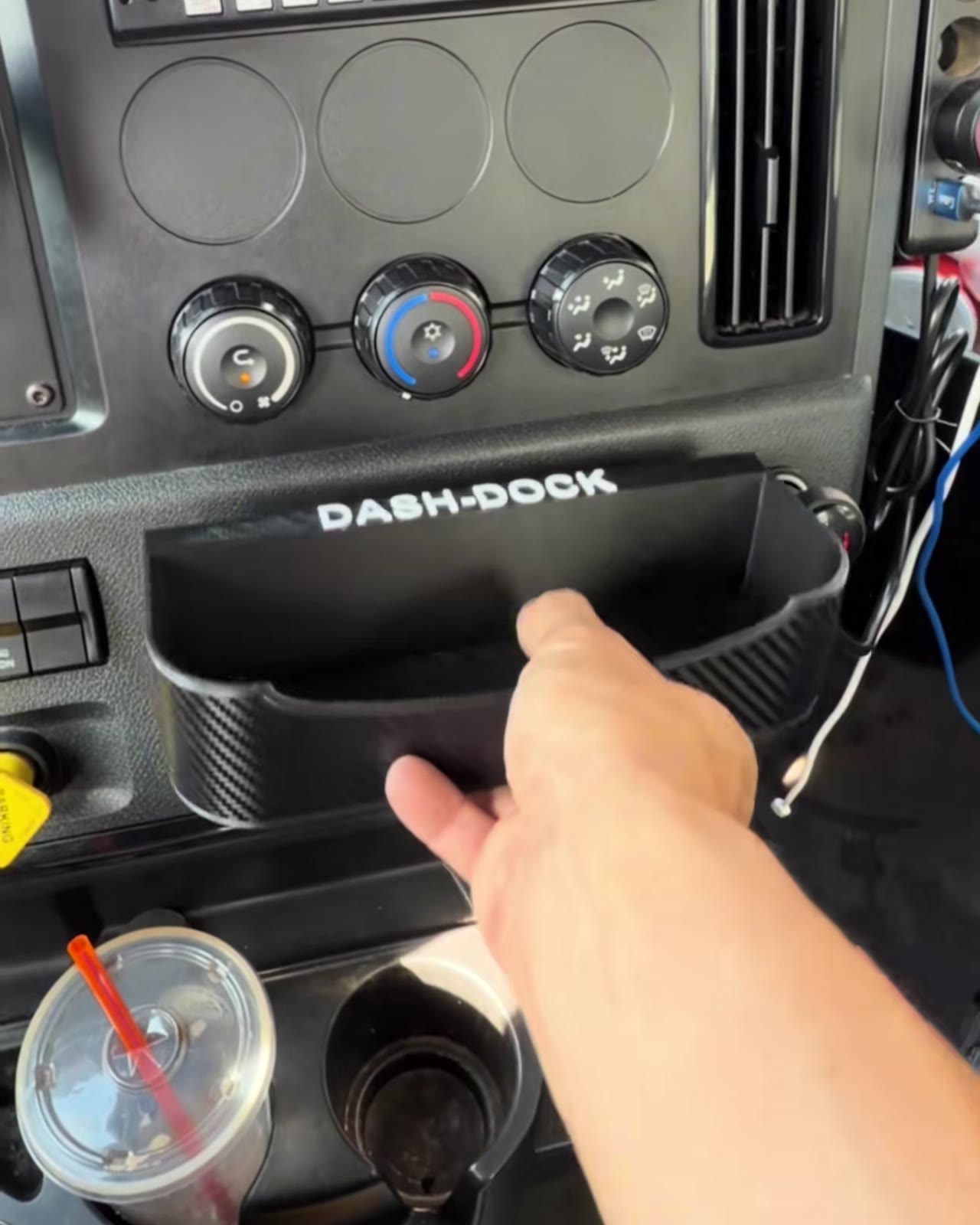 Dash-Dock tray seated in the same factory slot, holding a phone and pens